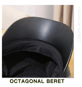 Close-up of black octagonal beret showing leather brim and high-quality fabric lining