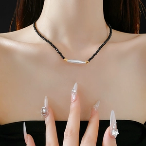 Detail of French vintage necklace with black crystals and a long freshwater pearl on a neck