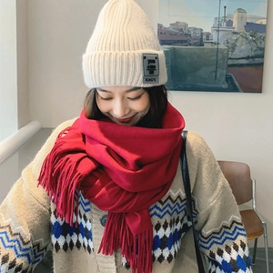 Winter set with beige knitted beanie and thick red wool scarf with fringe detail