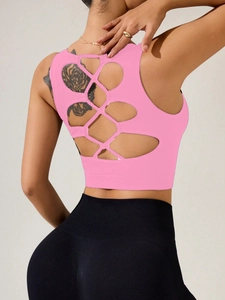 Détail d'un débardeur de sport rose avec dos croisé ajouré et ourlet élastique large