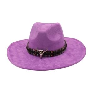 Purple felt cowboy hat with ethnic woven band and metallic bull head charm on white background