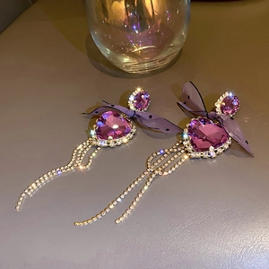 Detail of purple crystal heart earrings with sparkling tassel fringe and a bow knot