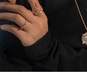 Detail of matte gold S925 silver rice grain ring with zircon and coin pendant necklace