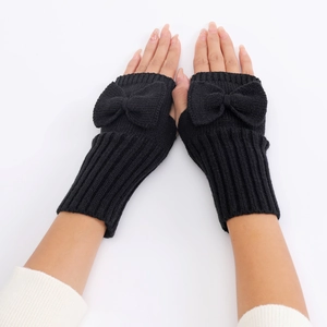 Close-up of black knitted fingerless gloves with bow detail and ribbed texture cuffs