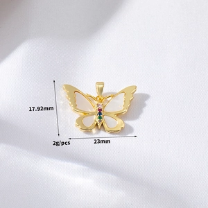 Macro view of gold butterfly pendant with white shell wings and colored cubic zirconia