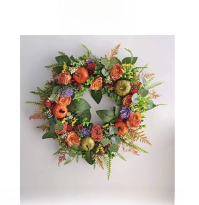 Detail of autumn wreath with orange roses, mini pumpkins, and purple thistle accents