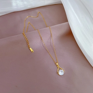Elegant gold-plated teardrop necklace with clear zircon pendant on light purple background