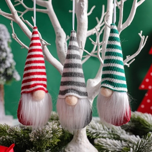 Three Christmas knitted gnome pendants in red, grey, and green stripes on branches