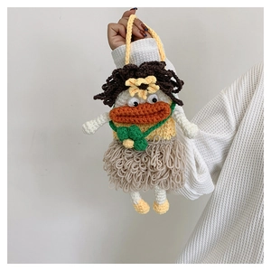Detailed macro view of a handmade crochet doll bag with yellow yarn and orange lips