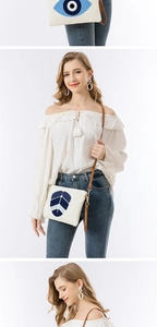 Detail der bestickten Canvas-Clutch mit Evil Eye-Muster und Leder-Schultergurt