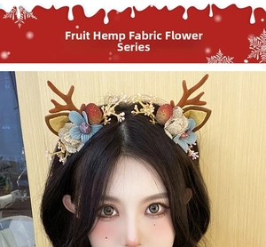 Detailed close-up of Christmas reindeer horn headband with linen flowers and red berries