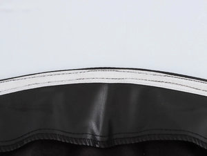Close-up of black PU leather skirt featuring white elastic waistband and stitching details