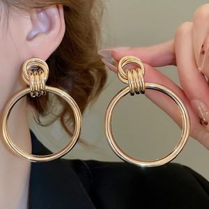 Detailansicht großer goldener Creolen mit Hochglanzfinish und Dreifachring-Verbindungsteil