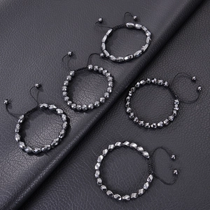 Handmade woven hematite bracelets in various irregular shapes on black leather background