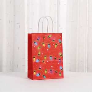 Festive red paper gift bag with colorful Christmas lights print and white twisted handles