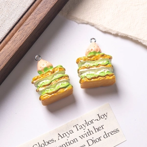 Macro shot of two strawberry matcha resin charms with cream layers and metal ring