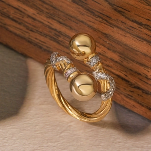 Macro shot of two-tone gold geometric ring featuring twisted texture and white zircons