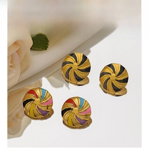 Macro shot of circular swirl enamel earrings in gold-plated stainless steel with vibrant colors