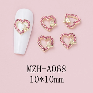 Macro view of 10x10mm pink heart nail charm with gold bow and sparkling rhinestones