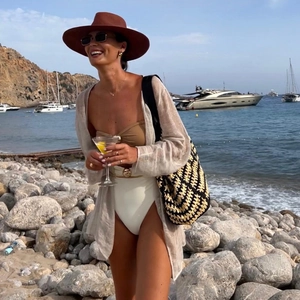 Detail of beach vacation set with brown swimsuit, straw hat, sunglasses and tote bag