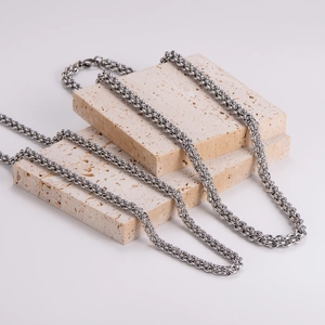 Sleek silver lantern chain link necklace displayed on decorative travertine stones
