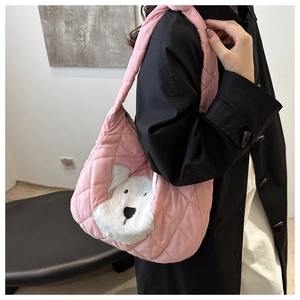 Detailed shot of pink quilted tote bag with cute white plush dog patch and zip closure