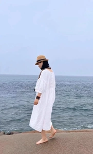 Detail of a vintage-style straw hat paired with a white linen bohemian summer dress