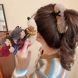 Detail of plush bear hair clips in various colors shown on model in cozy setting