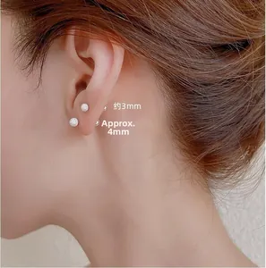 Detailed comparison of 3mm and 4mm round glitter stud earrings on a female model's ear