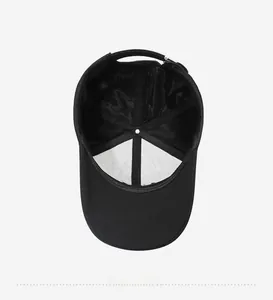 Internal detail of a black baseball cap featuring mesh lining and adjustable metal buckle