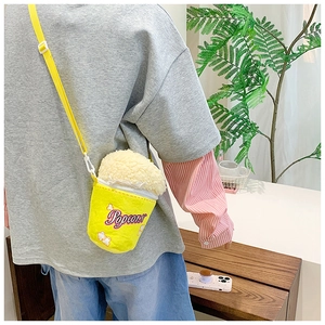 Detail of creative popcorn shaped plush bag with yellow strap and embroidered popcorn logo
