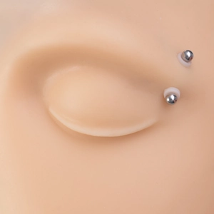 Piercing care silicone anti-friction discs and silver metal ball studs on skin model