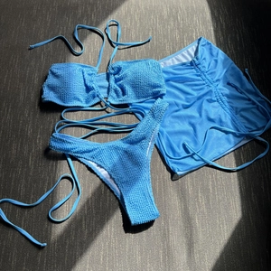 Macro detail of sky blue textured bubble fabric on a three-piece drawstring bikini set