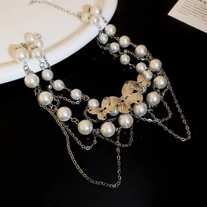 Detail of elegant double-layered pearl necklace with golden butterfly accents and tassels