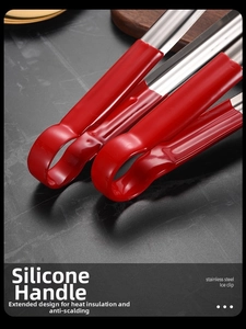 Detail of long stainless steel kitchen tong with red heat-resistant silicone handle grip