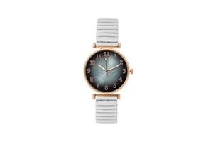 Detail of rose gold watch with monstera leaf dial and white stretch elastic band