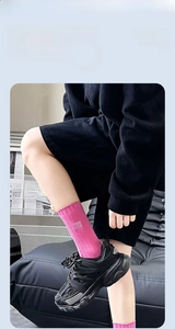 Détail de chaussettes mi-hautes côtelées rose vif avec étiquette et baskets