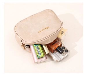 Top view of open beige leather bag showing large capacity for makeup and phone