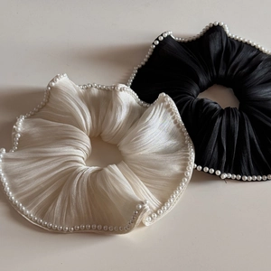 Detailed view of black and white mercerized scrunchies with elegant pearl edge trim