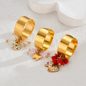 Detail of vintage gold rings with dangling beads and butterfly or fish charms