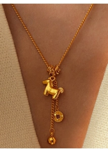 Detail of 24K gold plated necklace with horse pendant and coin charm on a model