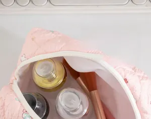 Close-up of pink quilted makeup bag with cat print showing large storage capacity