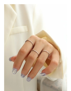 Three-piece set of minimalist silver titanium steel rings worn by model on finger