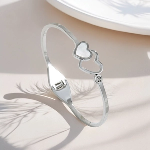 Detail of silver titanium steel bracelet featuring double hearts with white mother of pearl