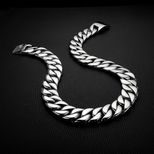 Macro view of thick silver stainless steel Cuban link necklace on black leather