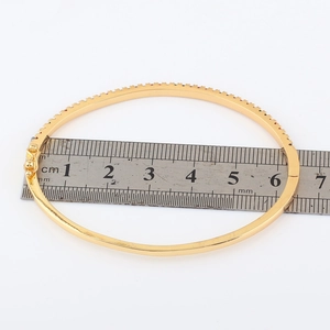 Measurement of 18k gold plated bangle with sparkling cubic zirconia on a white background