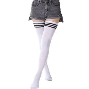 Détail de chaussettes montantes blanches avec trois rayures noires et maille
