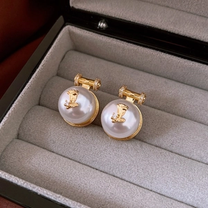 Detail of vintage round pearl earrings with gold rose carving and zircon accents