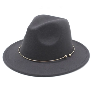 Detail of dark gray wool felt fedora featuring a gold metal ring with sphere accents