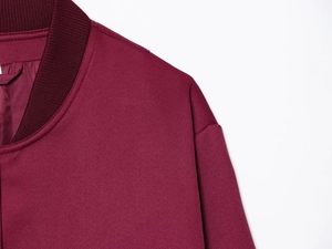 Detailed close-up of wine red jacket collar and shoulder stitching with ribbed texture